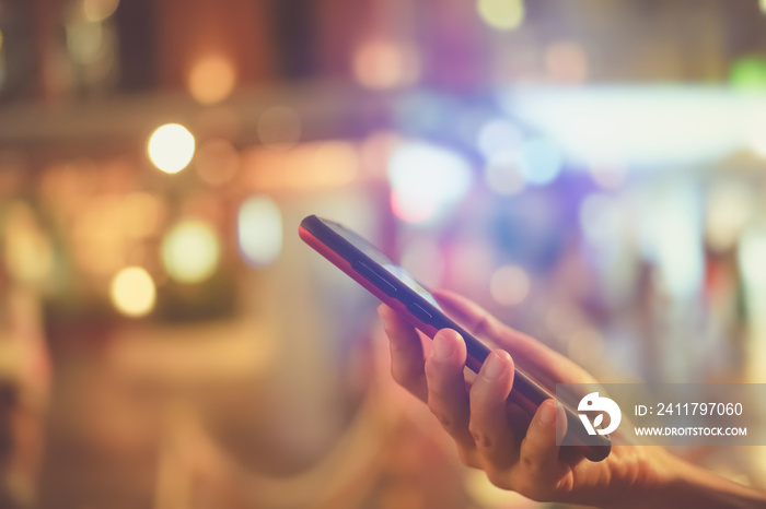 Woman hand using smartphone in mall