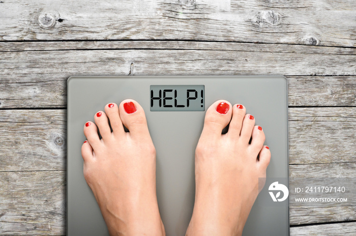 Help to lose kilograms with woman feet stepping on a weight scale