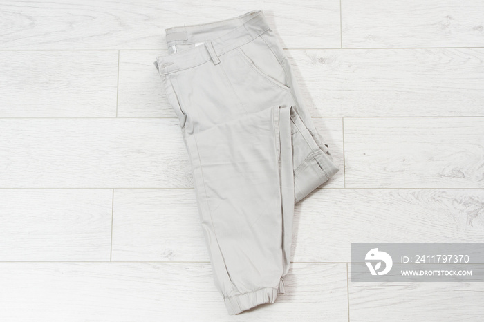 closeup folded pants on white wooden background - top view