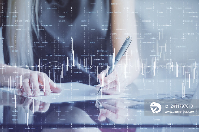 A woman hands writing information about stock market in notepad. Forex chart holograms in front. Concept of research.