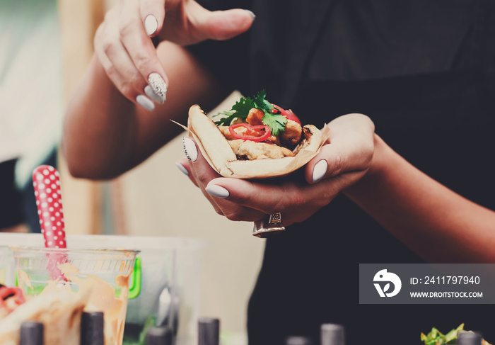 Street vendor hands making taco outdoors