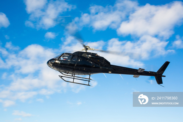 solo black helicopter in blue skies