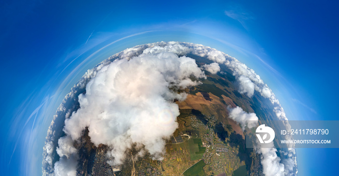 Aerial view from high altitude of little planet earth covered with white puffy cumulus clouds on sunny day