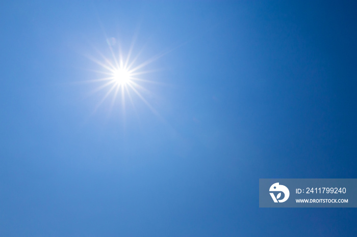 Shining sun on clear blue sky. lens flare of sunlight on blue sky background. Bright sun on blue sky.