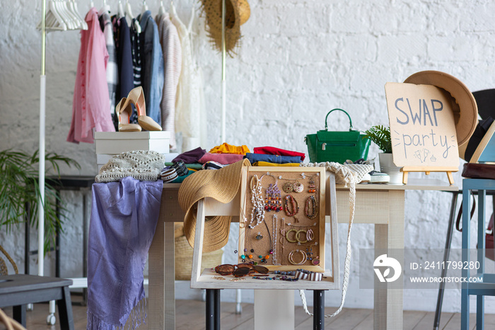 Young women at swap home party - clothes, shoes, bags, jewellery exchange between friends. Zero waste shopping, eco friendly concept, sustainable lifestyle. College life.