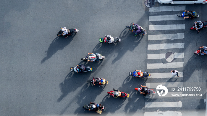 top aerial view of blur bikers ride the motorcycles to pass pedestrian crosswalk on road with the traffic pattern signage on the street