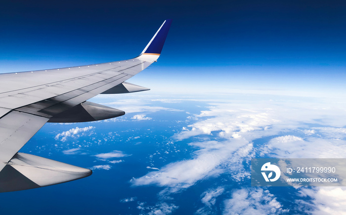 Sky view from inside the plane. The wing of the plane and the sky can be seen from inside the plane. There is a space for writing space