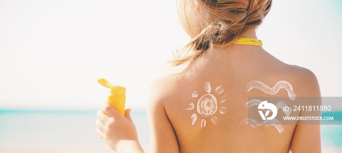 child on the beach smears sunscreen. Selective focus.