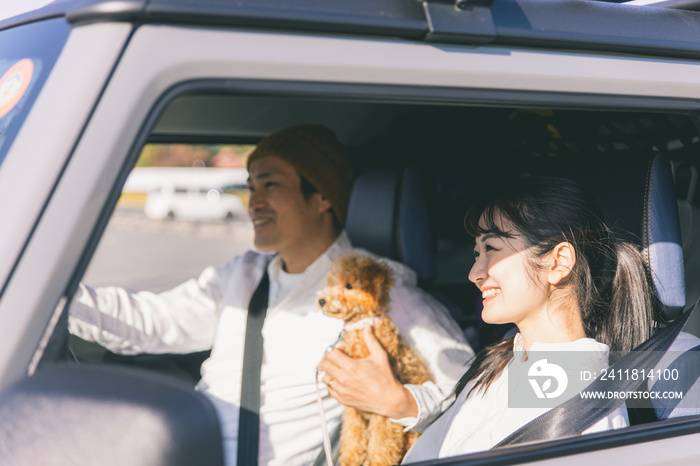 車でお出かけする犬と男女（車内）