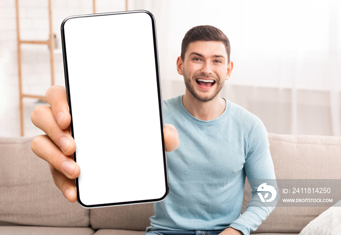 Mobile Offer. Joyful Young Man Showing Blank White Smartphone Screen At Camera