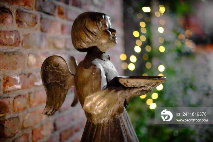 Bronze statue of an Angel in front of christmas illumination, at the chapel  Roskapellchen  in Aache