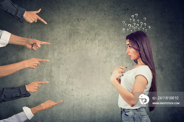 Anxious surprised woman being judged by different people pointing fingers at her.