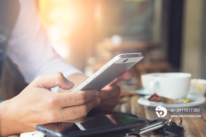 Young man using smartphone in coffee cafe, always connected concept