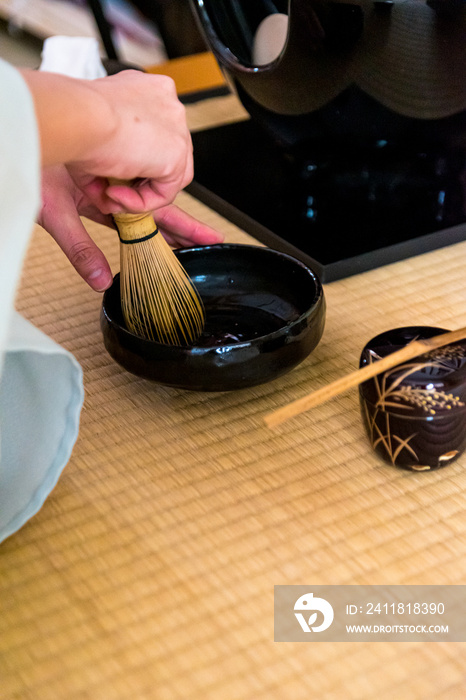 日本女人，茶艺大师，Sen Rikyu，在日本特拉华州用手净化一个竹抹茶搅拌器