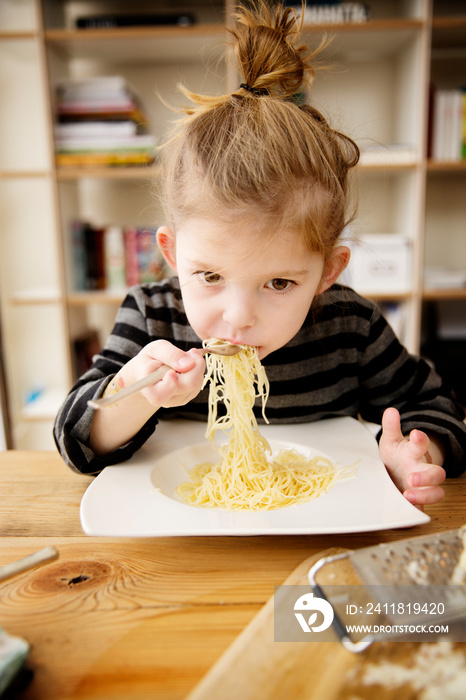 Girl (4-5) eating spaghetti