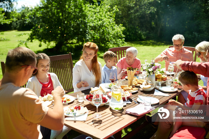 休闲、度假和人的概念-幸福的家庭享用节日晚餐或夏季花园派对