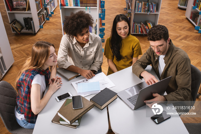 University students are studying in a library together. Concept of teamwork and preparation