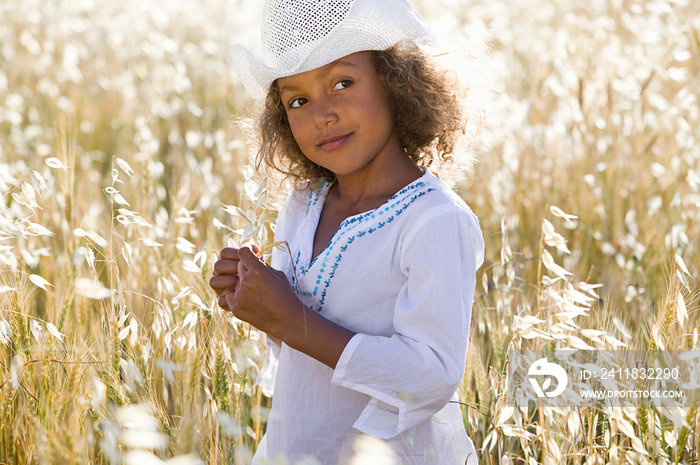 Girl wearing white cowboy hat in field