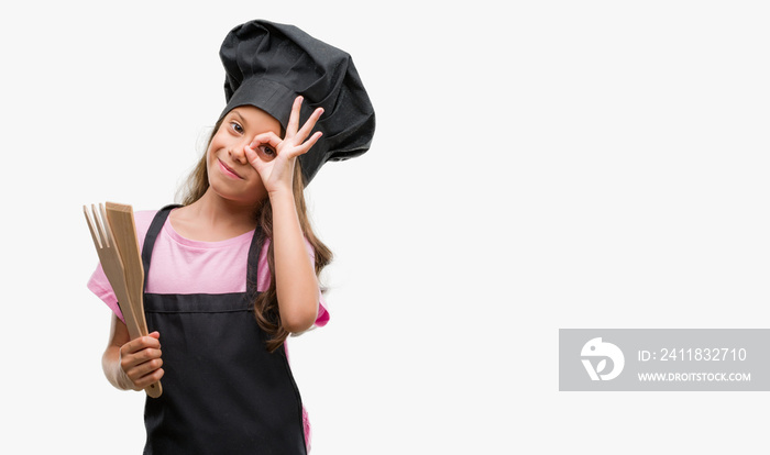 Brunette hispanic girl wearing cook uniform with happy face smiling doing ok sign with hand on eye l