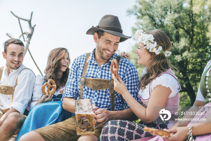 Five friends having fun on Bavarian RIver and clinking glasses with Oktoberfest beer