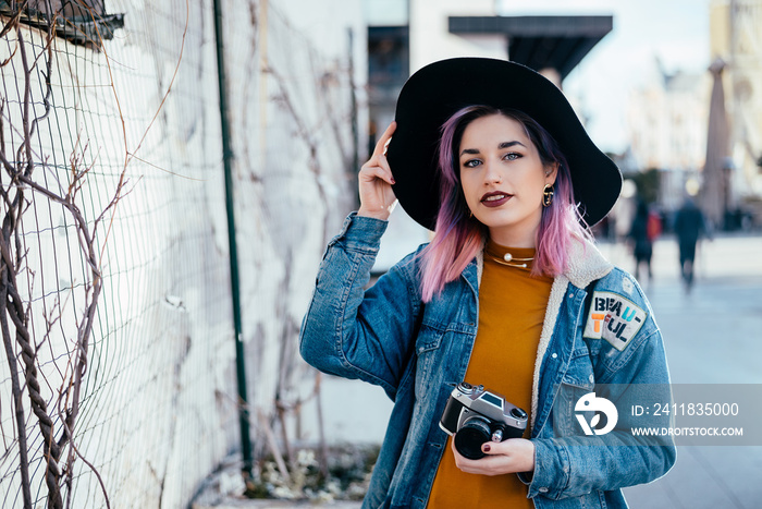 Portrait of a hipster girl with a hat at city street.