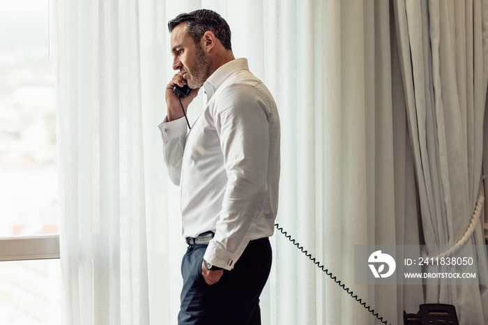 Businessman making call from hotel room