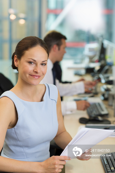 Portrait confident businesswoman with paperwork in office