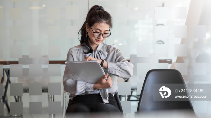 Young Asian businesswoman holding a portfolio looks at the clock waits for a job interview at the of