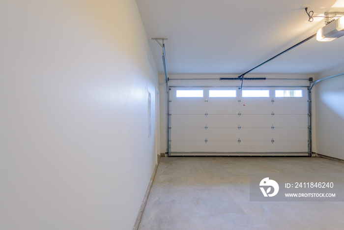 An empty garage with door and windows.