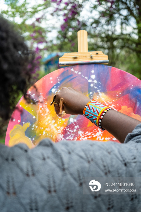 over-the-shoulder view of a female artists abstract painting