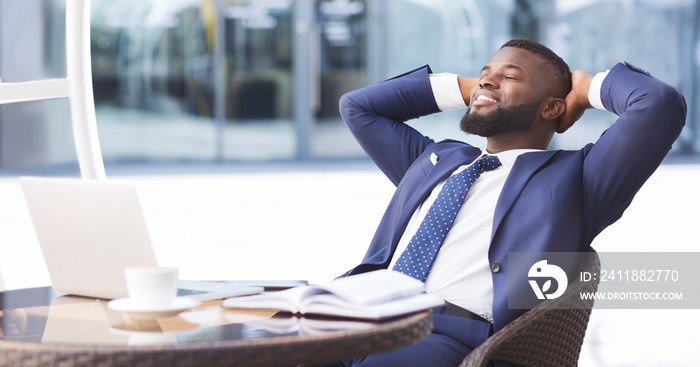 Cheerful black businessman relaxing in outdoor cafe, panorama