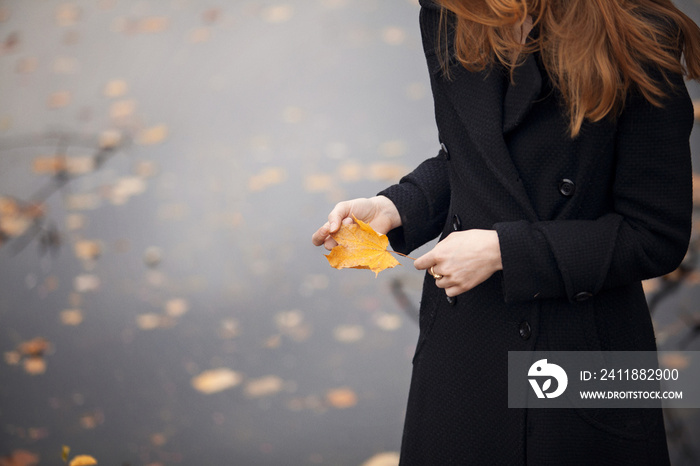 抱着秋黄叶的女人的中段