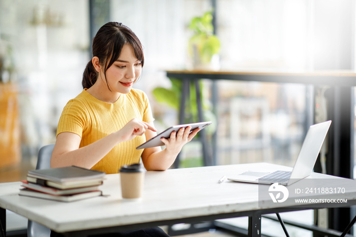 亚洲年轻女商人在平板电脑上分析财务数据