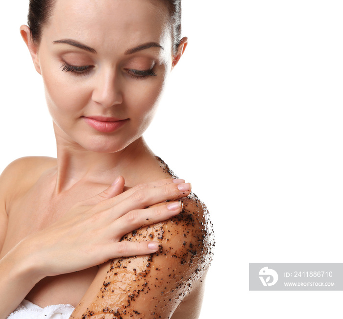 Beautiful young woman applying scrub on shoulder