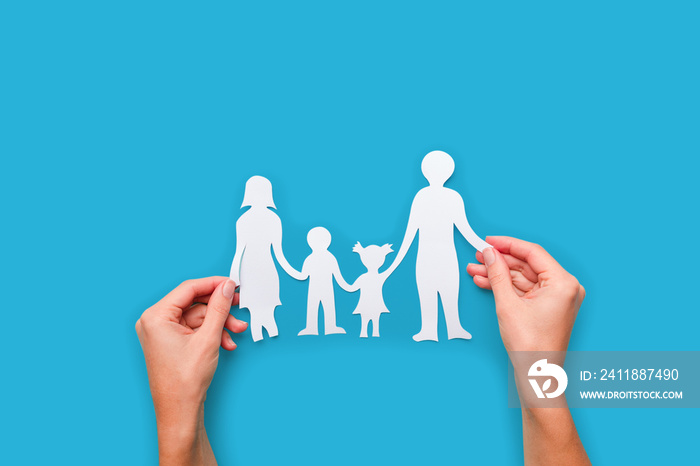 Paper family in hand isolated on blue background