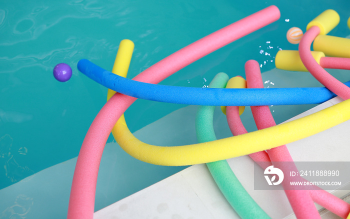 water aerobic equipment. colored aqua noodles in swimming pool.
