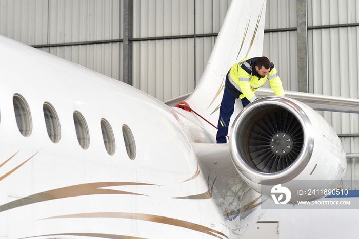 Aircraft mechanic inspects and checks the technology of a jet in a hangar at the airport