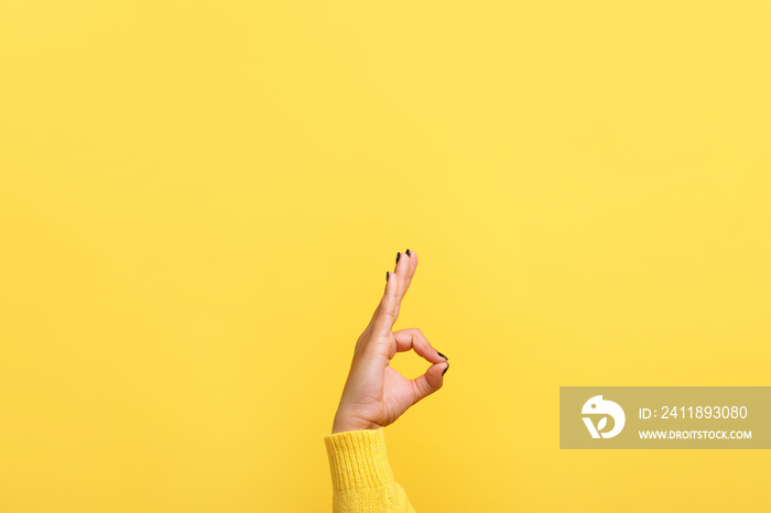 hand ok sign over trend yellow background