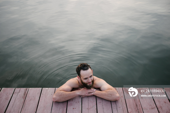 Man relaxing and swimming in the lake or a wimming pool