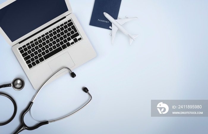 international medical travel insurance concept, stethoscope, passport, computer laptop and airplane 