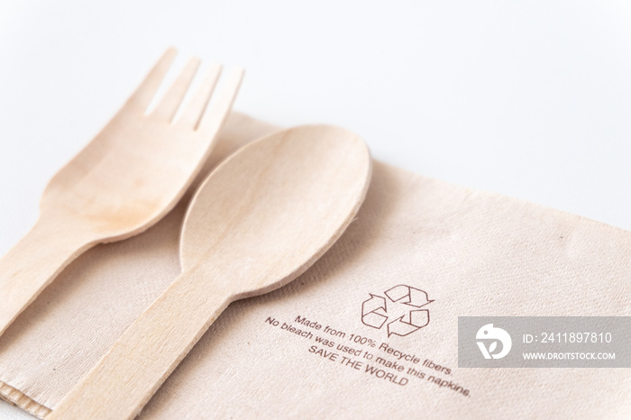 Recycle eco friendly disposable wood spoon fork and napkin paper in top view isolated on white table