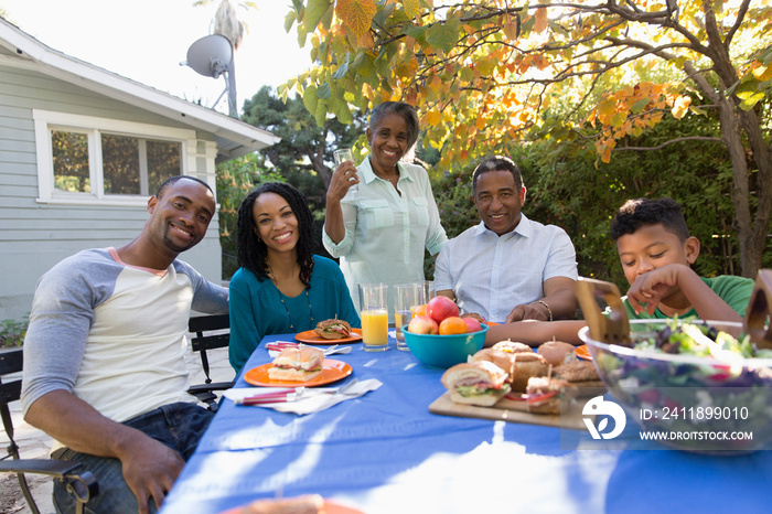 Portrait happy multi-generation family enjoying lunch on autumn patio