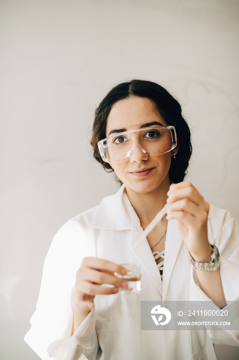 Portrait of confident science student experimenting in laboratory at university