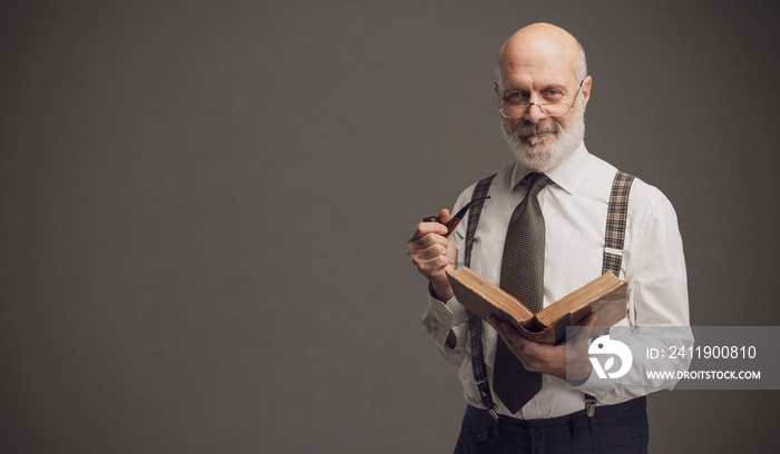 Smiling professor smoking a pipe and reading