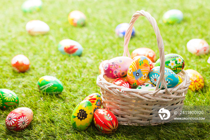 Unique hand painted Easter eggs in basket on grass