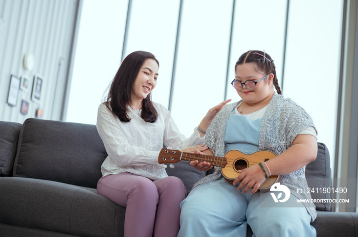 Autistic girl plays the guitar with her mom at her holiday home.