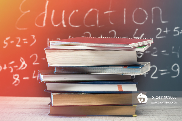 education word on chalkboard with school books on desk, education concept