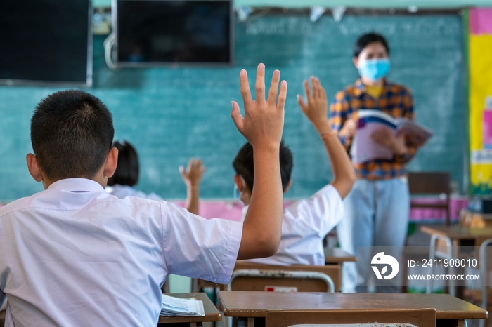 亚洲小学生戴着防护口罩以防新冠肺炎，你的学生