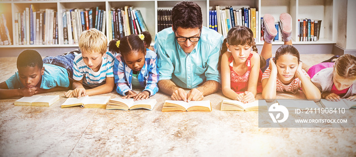 Teacher and kids reading book in library