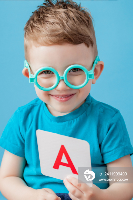 Cute little boy with letter on background. Child learn letters. Alphabet